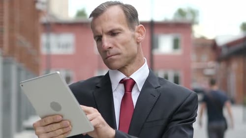 Man Using Tablet Outdoors in City