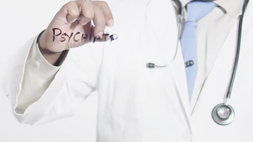 Doctor Writes the Word Psychiatry on Glass