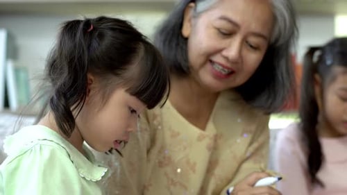 Senior Woman Helping Child Indoors
