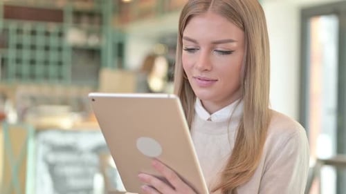 Woman using tablet in cafe