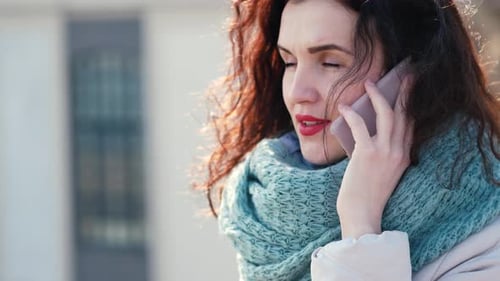 Upset Curly Girl Talking on the Phone on the Street. Hair Dispels Her Dark Hair