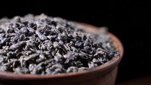 Tea Leaves Fall on a Pile of a Green Tea - Macro Shot.