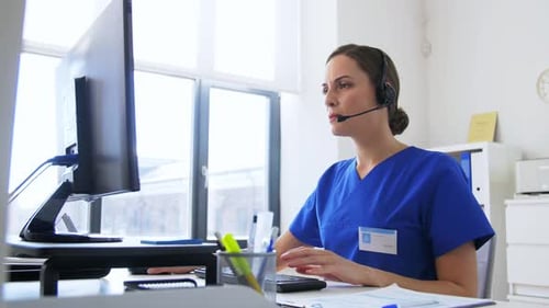 Doctor with Headset and Computer at Hospital