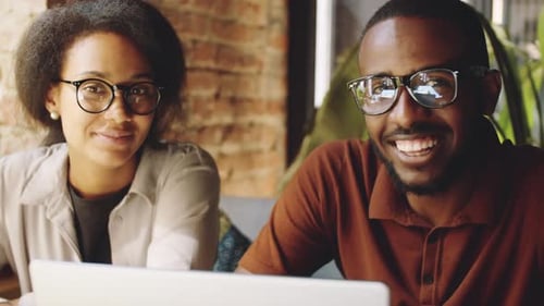 Joyous Afro-American Colleagues Smiling at Camera in Cafe