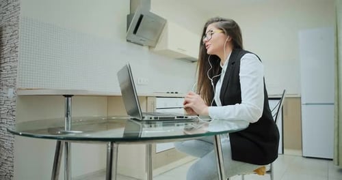 Woman Video Conferencing on Laptop in Kitchen
