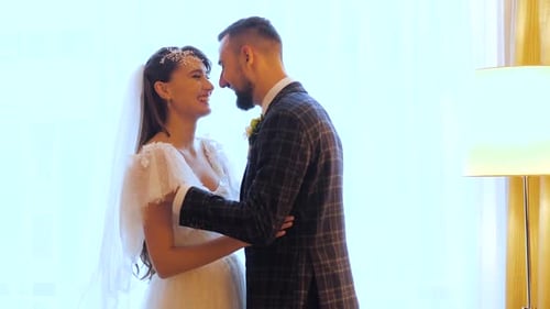 Happy Wedding Couple Smiles and Hugs in a Cozy Room of a Luxury Hotel in Kharkov, Ukraine. Bearded