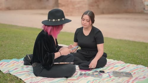 Two Young Adults Drawing Together in the Park