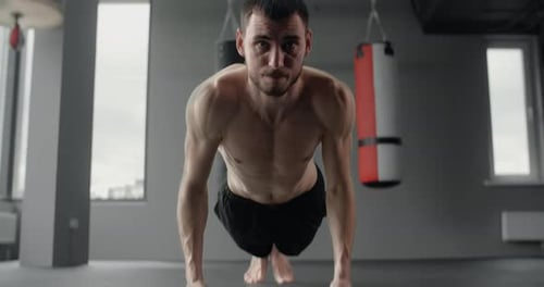 Athlete Performs Fast Pushups on His Fists at the Gym Camera Follows the Movement Workout Training