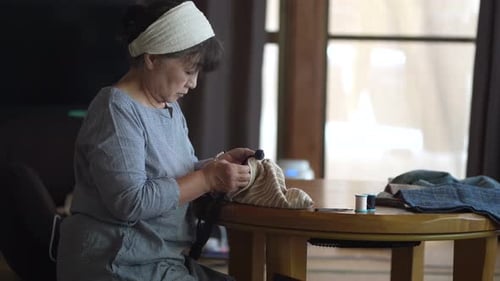 Woman Hand Sewing at Table in Natural Light