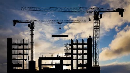 Cranes Constructing Building at Sunrise