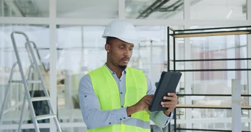 Builder Checking Details of Building Plan on Tablet PC when Standing Inside in Built Office Building
