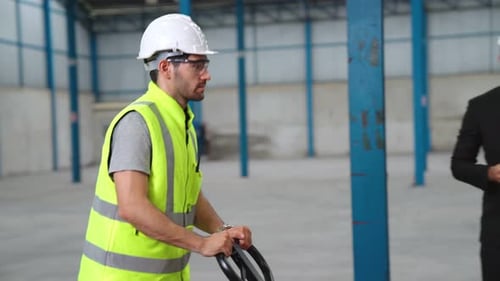 Factory Workers Deliver Boxes Package on a Pushing Trolley in the Warehouse