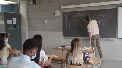 Mathematics Teacher Teaching Students in a Classroom