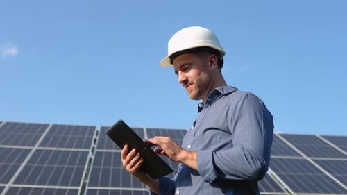 Ingenieur Solar-Photovoltaik-Panel-Station überprüft mit Tablet-Computer