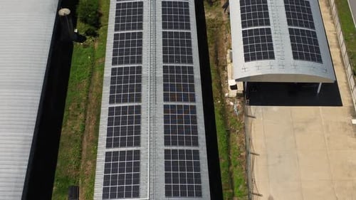 Aerial view of Solar panels installed on a roof of a large industrial building or a warehouse.