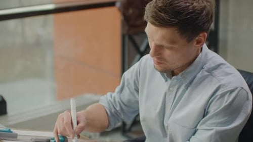 Man Drawing Architectural Plans in the Office
