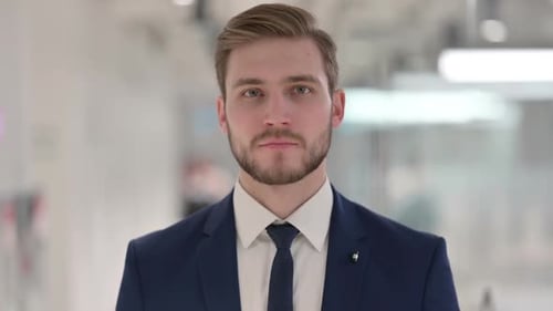 Man in Suit Looks Towards Camera in Office