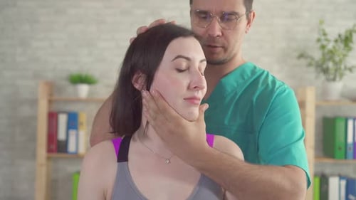 Männlicher chiropaktischer Massagetherapeut behandelt junge Patienten aus nächster Nähe von Nackenschmerzen