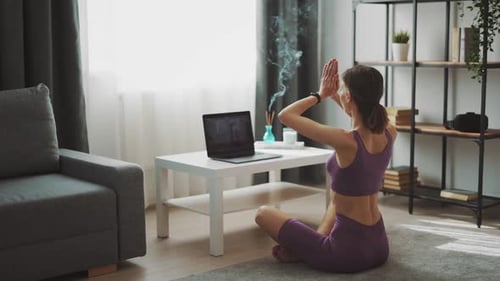 Woman Practicing Yoga at Home Using Laptop