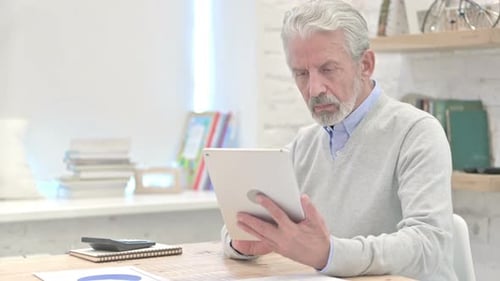 Old Man Using Tablet in Office