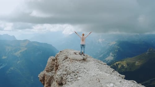 Happy Free Woman with Outstretched Hands on the Top on the Rock