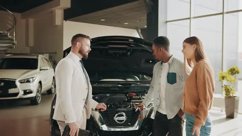 Salesperson Explains Car Engine to Couple in Showroom
