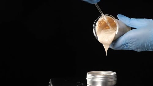 Cream Being Poured into Silver Container