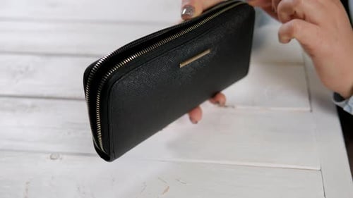 Woman Opens Black Wallet and Removes Money