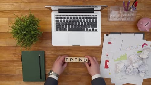Word Trend besteht aus Holzwürfeln, Buchstaben auf dem Bürotisch neben dem Notizbuch