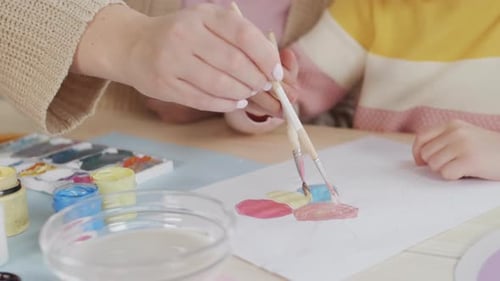 Adult and Child Painting Together at Table