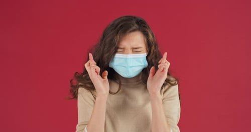 Young Woman Pleading with Fingers Crossed