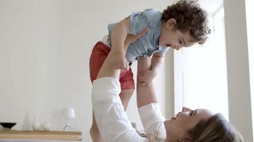 Mother Plays With Laughing Child At Home