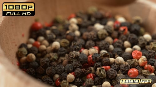 Colorful peppercorns being ground in slow motion