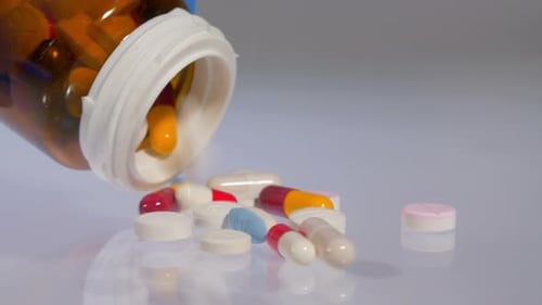 Assorted Pills Spilling Out of Prescription Bottle