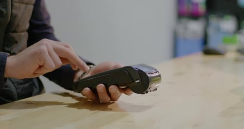 Male Customer Paying for Purchase and Using Credit Card at Bank Terminal in Store Rbbro