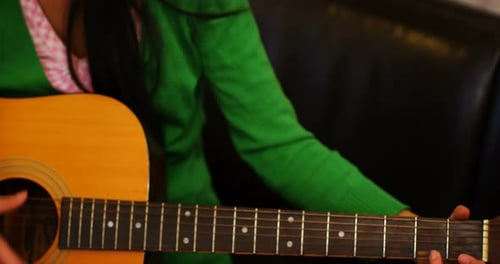 Young Woman Plays Acoustic Guitar Indoors