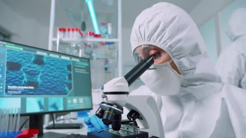 Scientist Works with Microscope in Bright Lab