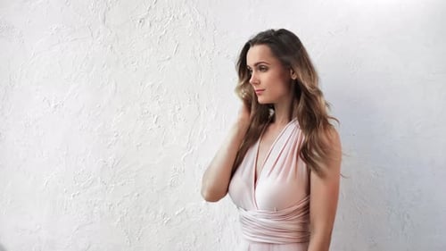 Woman Posing in Light Pink Dress Against White