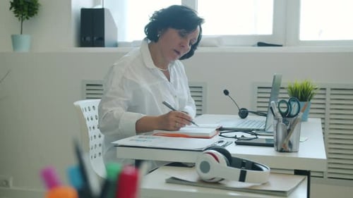 Slow Motion of Ambitious Businesswoman Working with Laptop and Writing in Notebook in Office