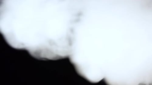 Fumée blanche flottant dans l'espace sur fond noir. Effet de brume, de fumée, de vapeur, de brouillard.