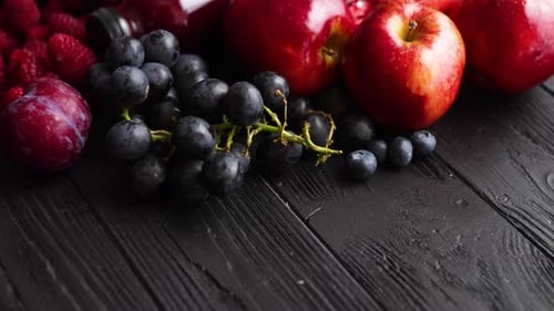 Various Fresh Red, Purple Black Fruits. Mix of Fruits and Bottled Juices on Black