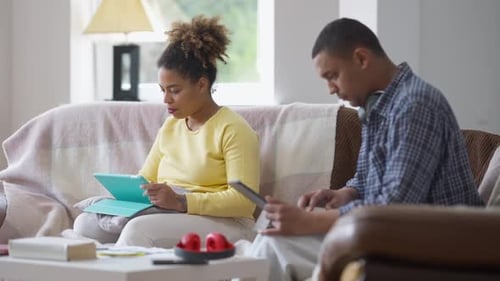 Woman and Man Using Tablets on Couch