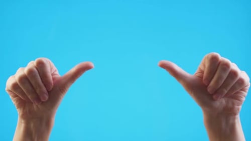 Woman Hands Pointing on Copyspace and Showing Thumbs Up Over Blue Background