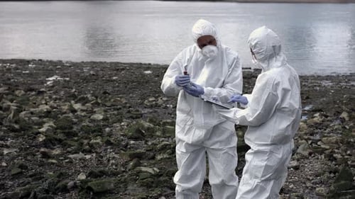 Científico forense examina una muestra en la orilla del río