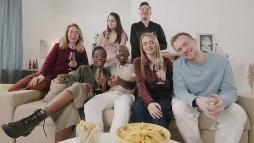 Friends Gathering, Toasting with Stemware on Sofa