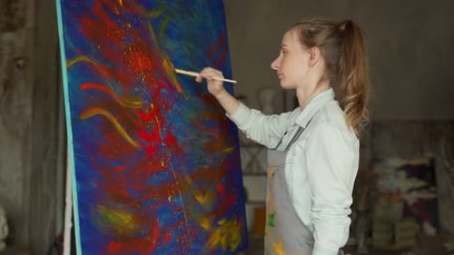Young Woman Painting Abstract Art in Urban Studio