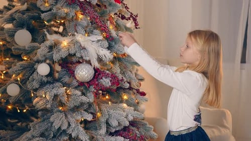 Child Decorating Beautiful Christmas Tree with Ornaments