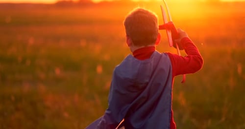 The Boy Presents Himself As a Pilot and Runs Into the Field at Sunset with a Plane