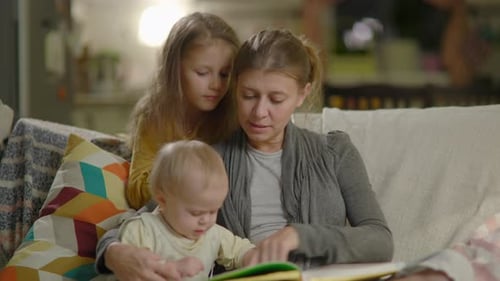 Mother Reading Book to Children at Home