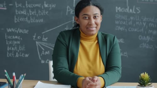 Slow Motion Portrait of African American Woman English Teacher Smiling in Classroom with Chalkboard